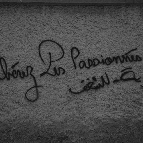a black and white photo of graffiti on a wall