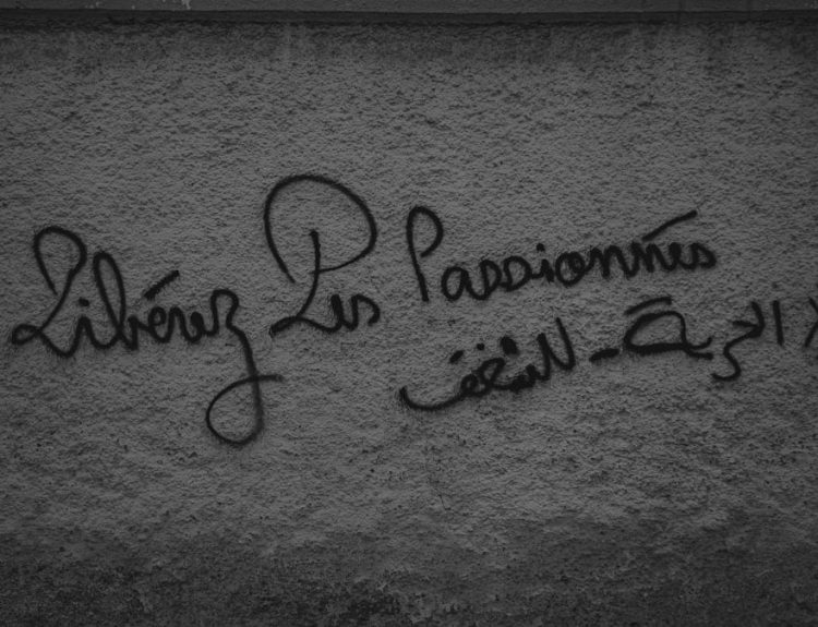 a black and white photo of graffiti on a wall